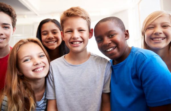 Portrait Of Smiling Male And Female Students In Grade School Classroom